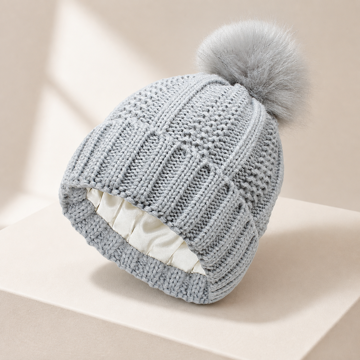 Bonnet côtelé doublé gris clair à pompon — Light-grey lined rib-knit pom-pom beanie