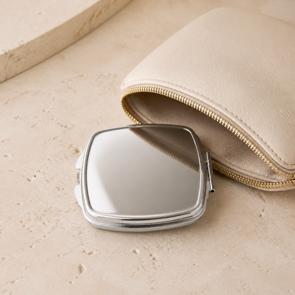 Miroir compact carre pres d une trousse de beaute — Square compact mirror beside a beauty pouch