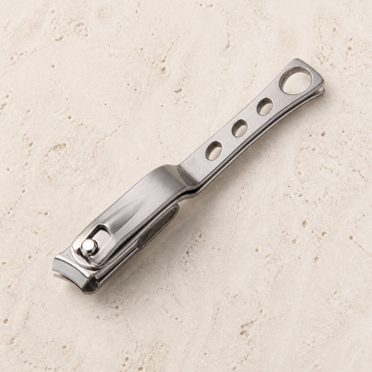Coupe-ongles rotatif en acier, vue du dessus — Rotating stainless-steel nail clipper, top view